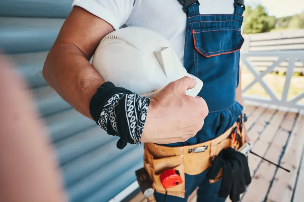 Artisan équipé de sa ceinture à outils avant une réparation de volet roulant
