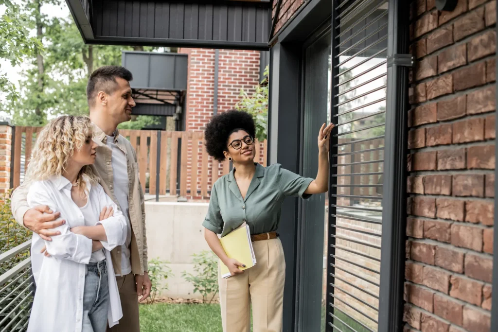 Conseillère présentant des stores extérieurs à un couple devant leur maison
