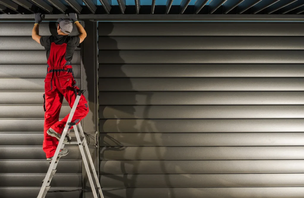 Technicien sur un escabeau installant une protection solaire extérieure – stores extérieurs à Pégomas