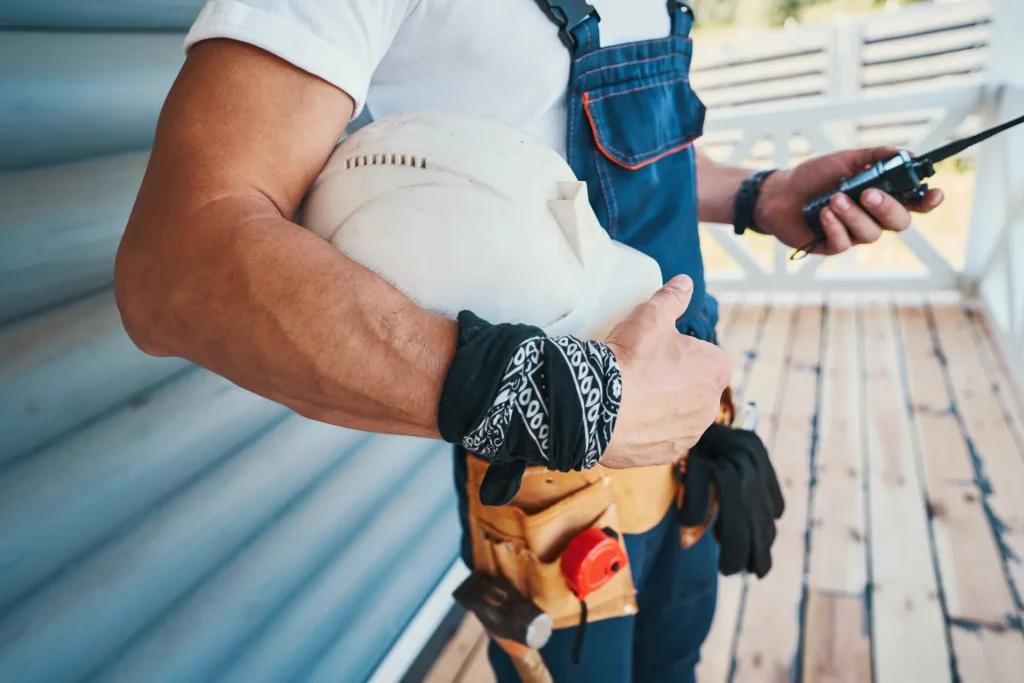 Technicien sur un chantier, casque et talkie-walkie à la main
