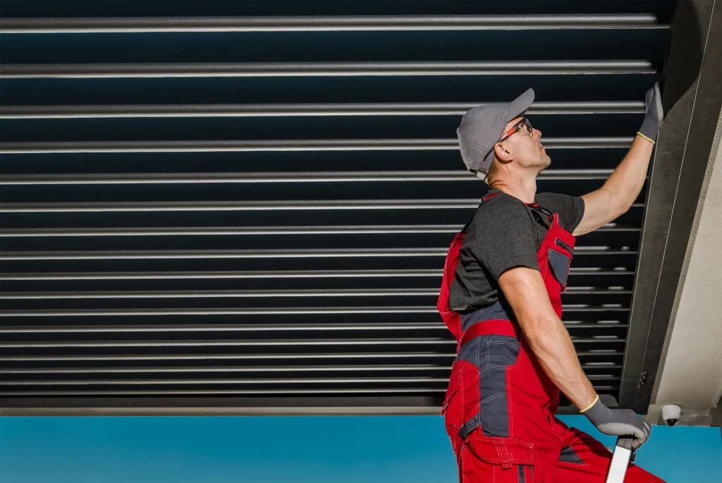 Technicien réglant une protection solaire extérieure à lames – réparation de store banne à Nice