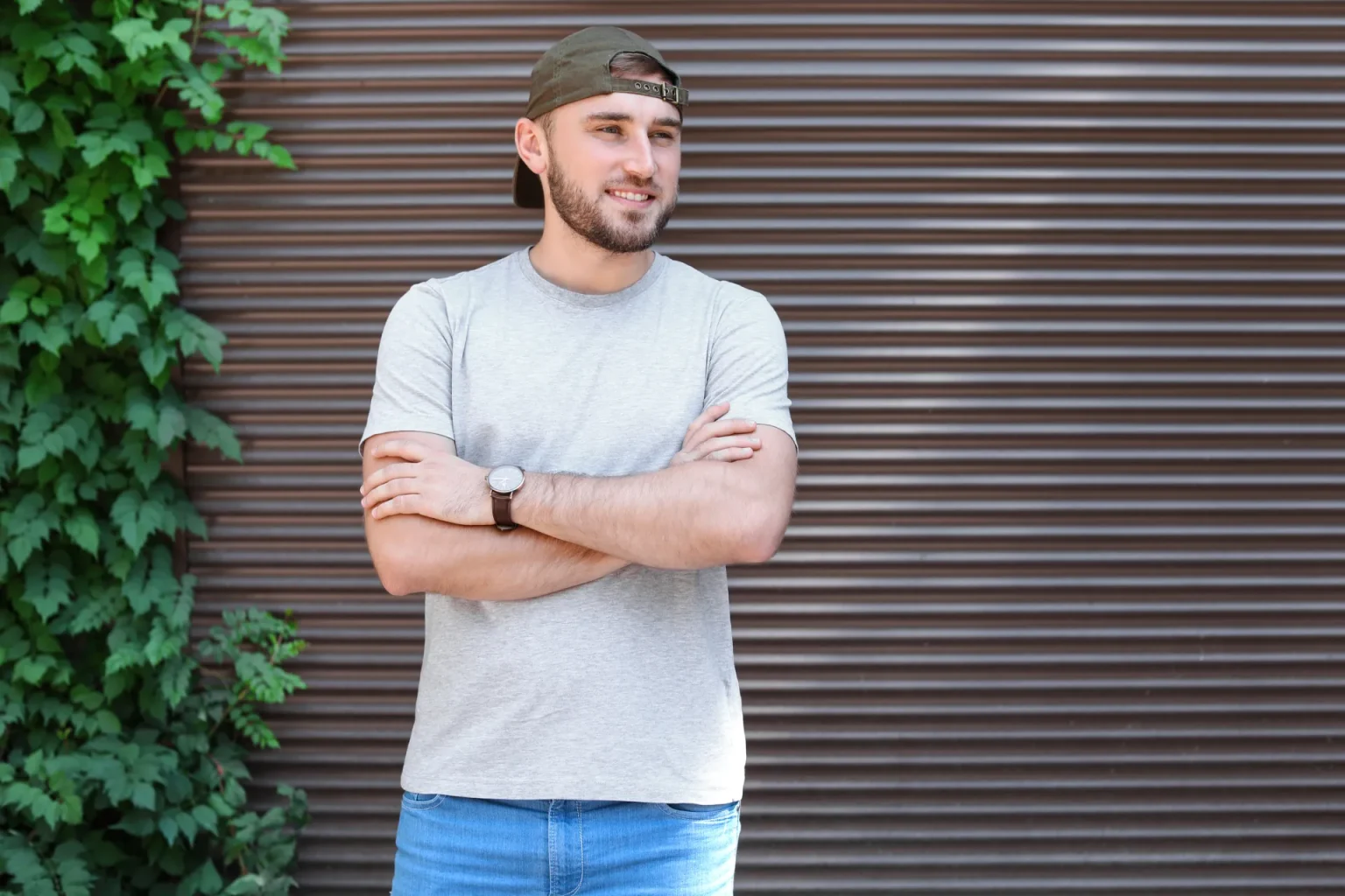 Volet roulant marron fermé sur une façade avec du lierre