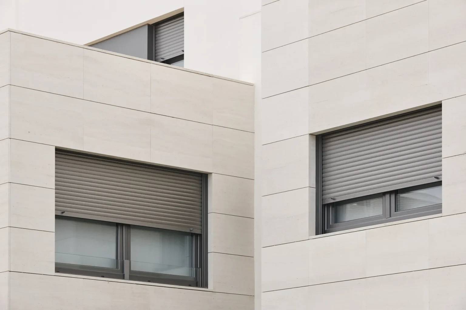 Volets roulants en aluminium gris sur une façade moderne