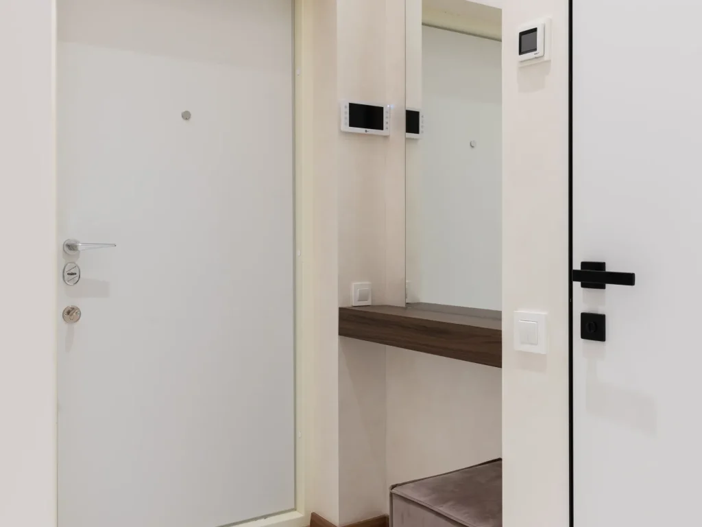 Porte d’entrée blanche dans le hall d’un appartement, après une installation de porte blindée à Cap-d’Ail