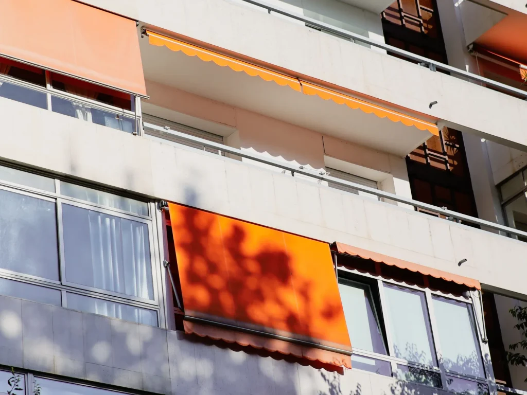 Stores de balcon orange sur la façade d’un immeuble – stores extérieurs à Biot