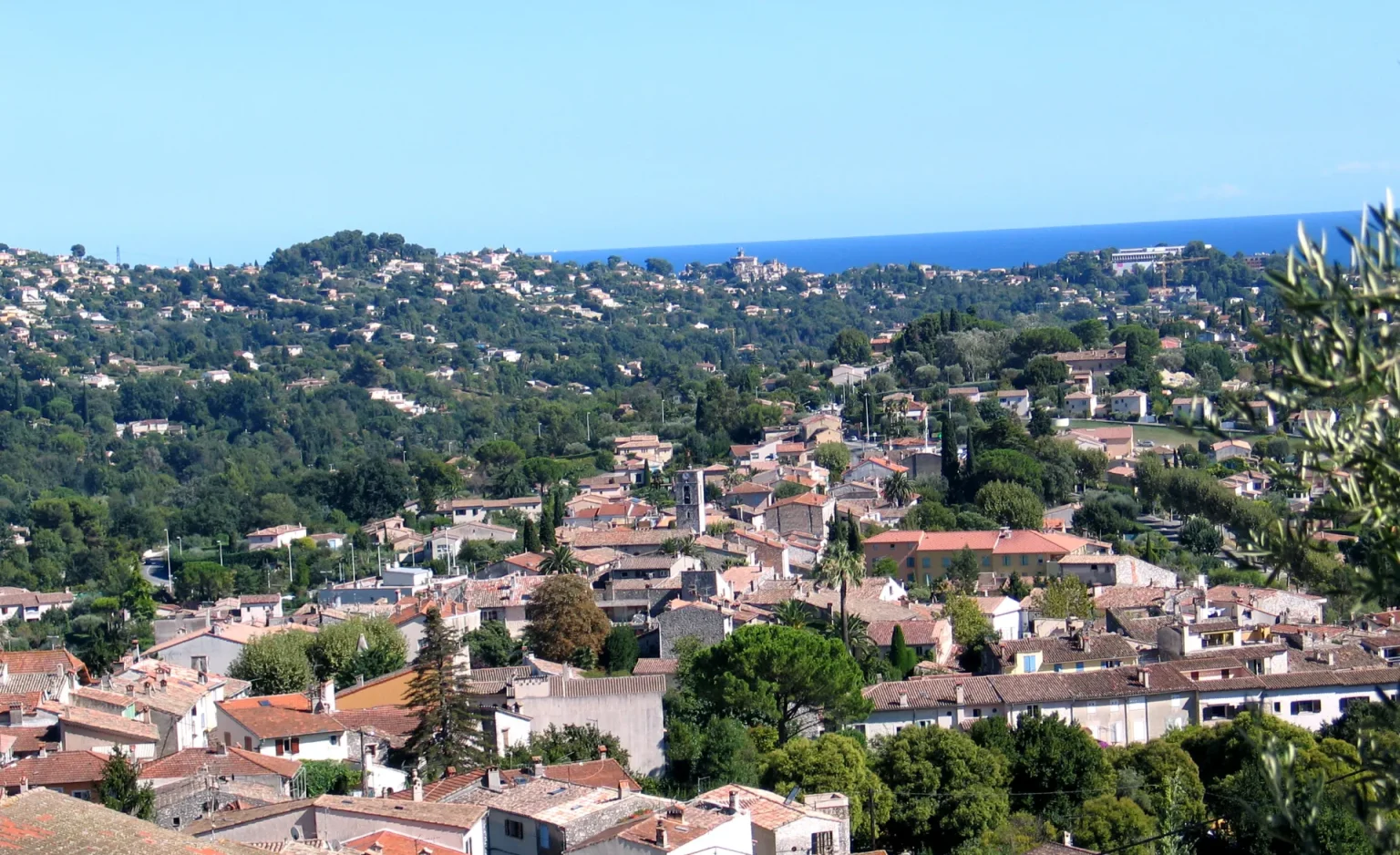 Vue d'ensemble du village de La Colle-sur-Loup, avec la mer Méditerranée à l'horizon