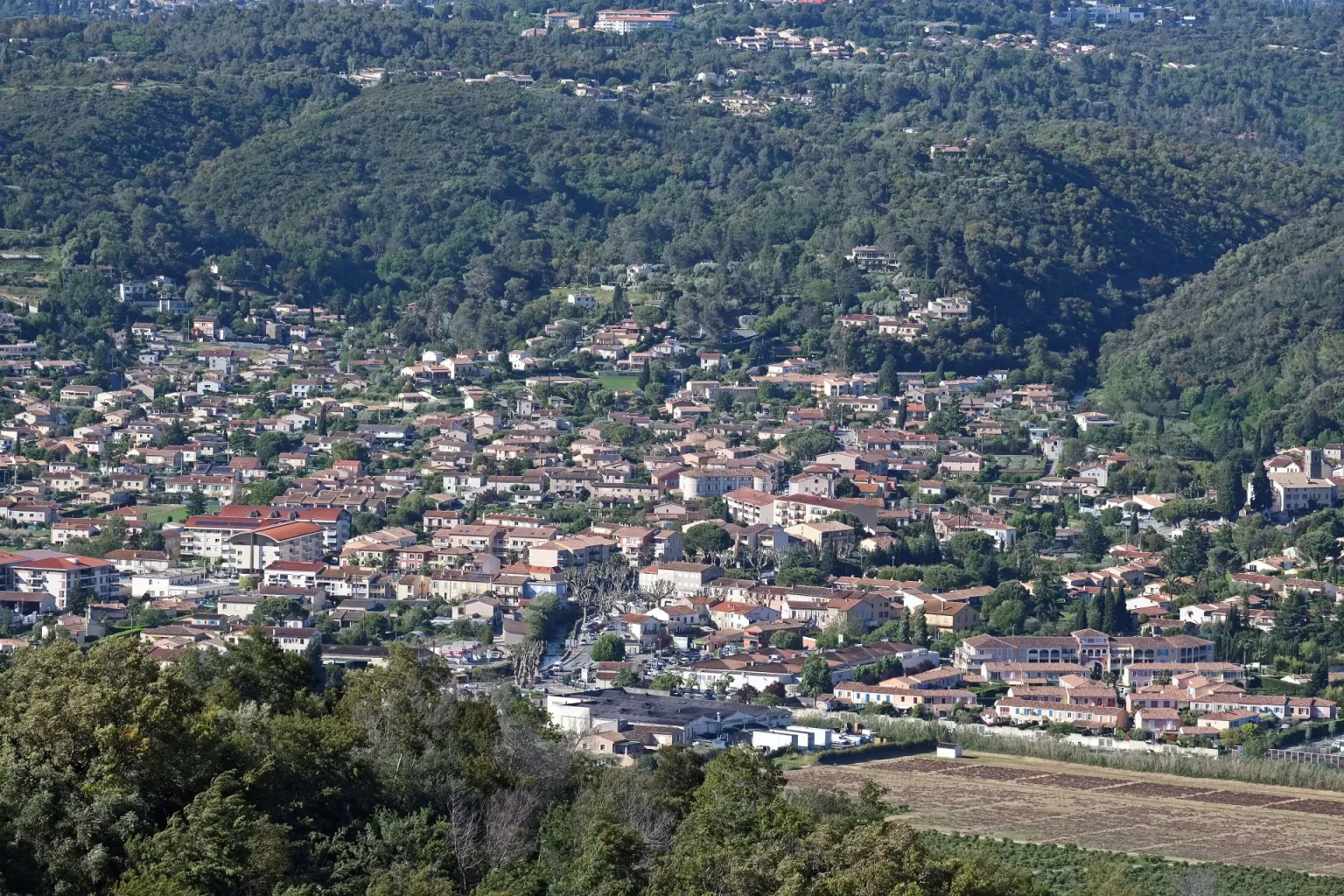 Vue d'ensemble du village de Pégomas au pied des collines boisées